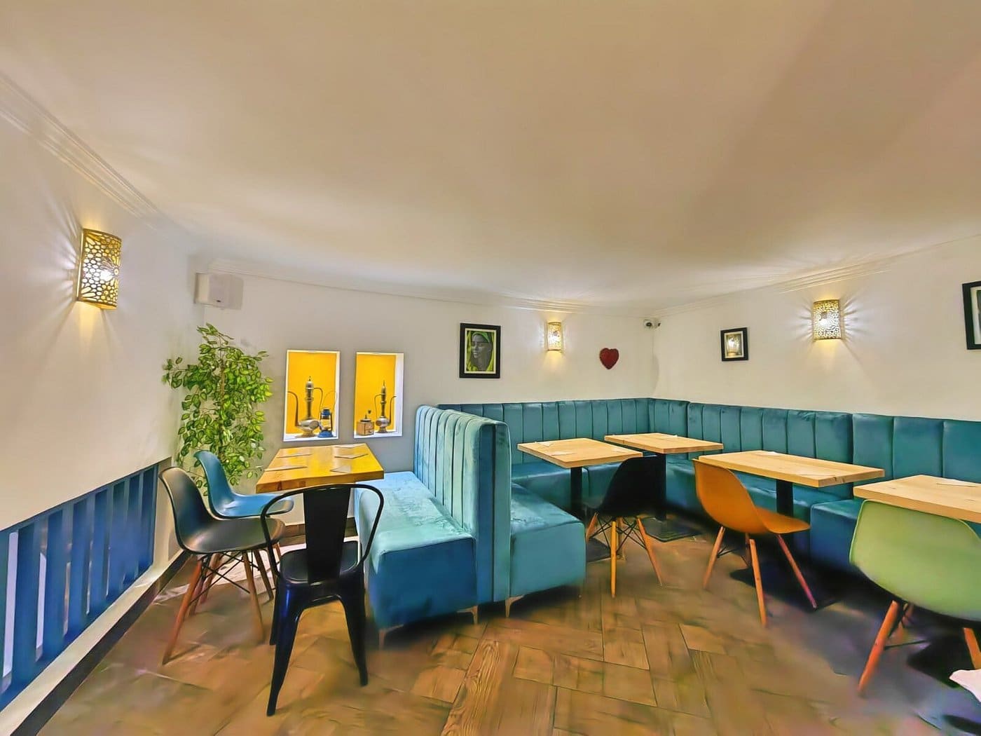 The mezzanine's curved teal velvet banquette and warm wall sconces